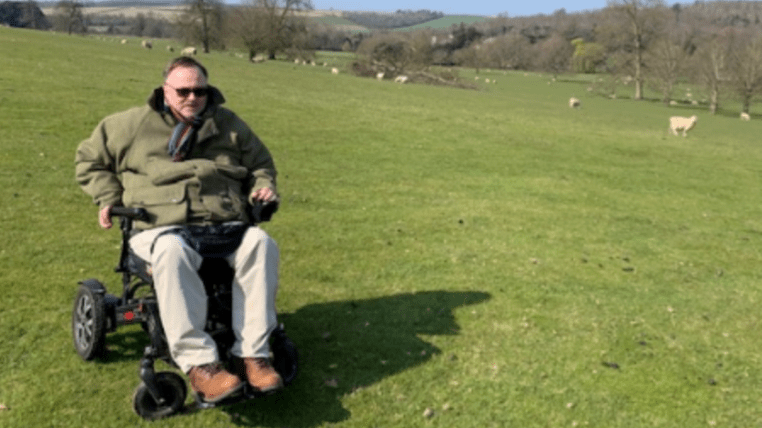 Man on wheelchair outside in field